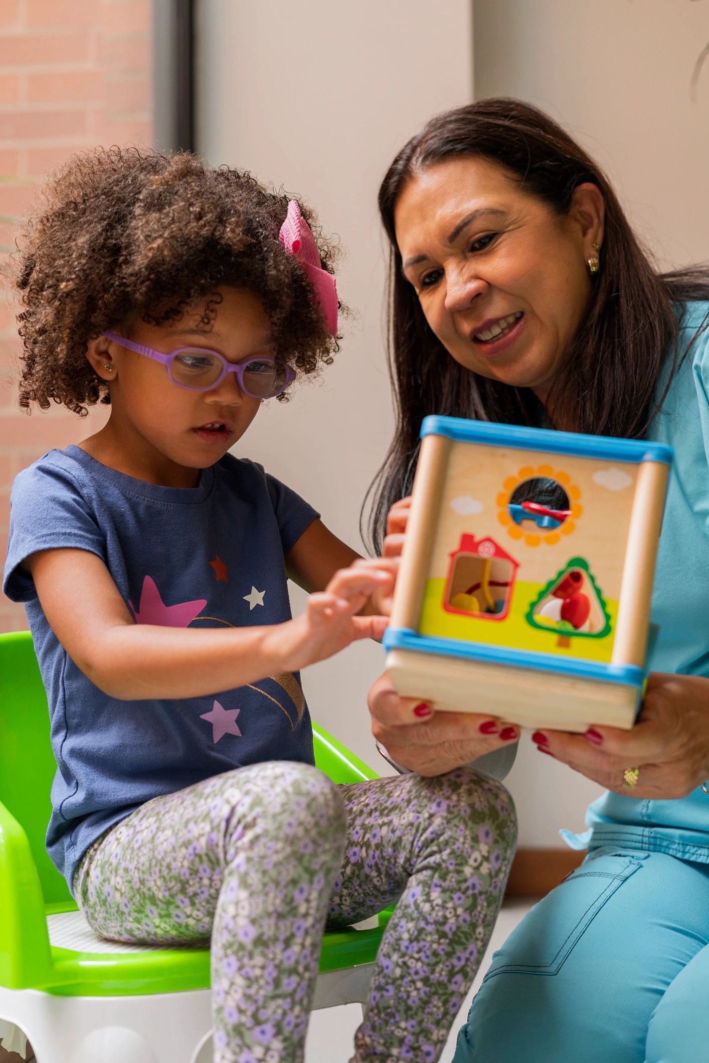 Child and adult playing with shape sorter.