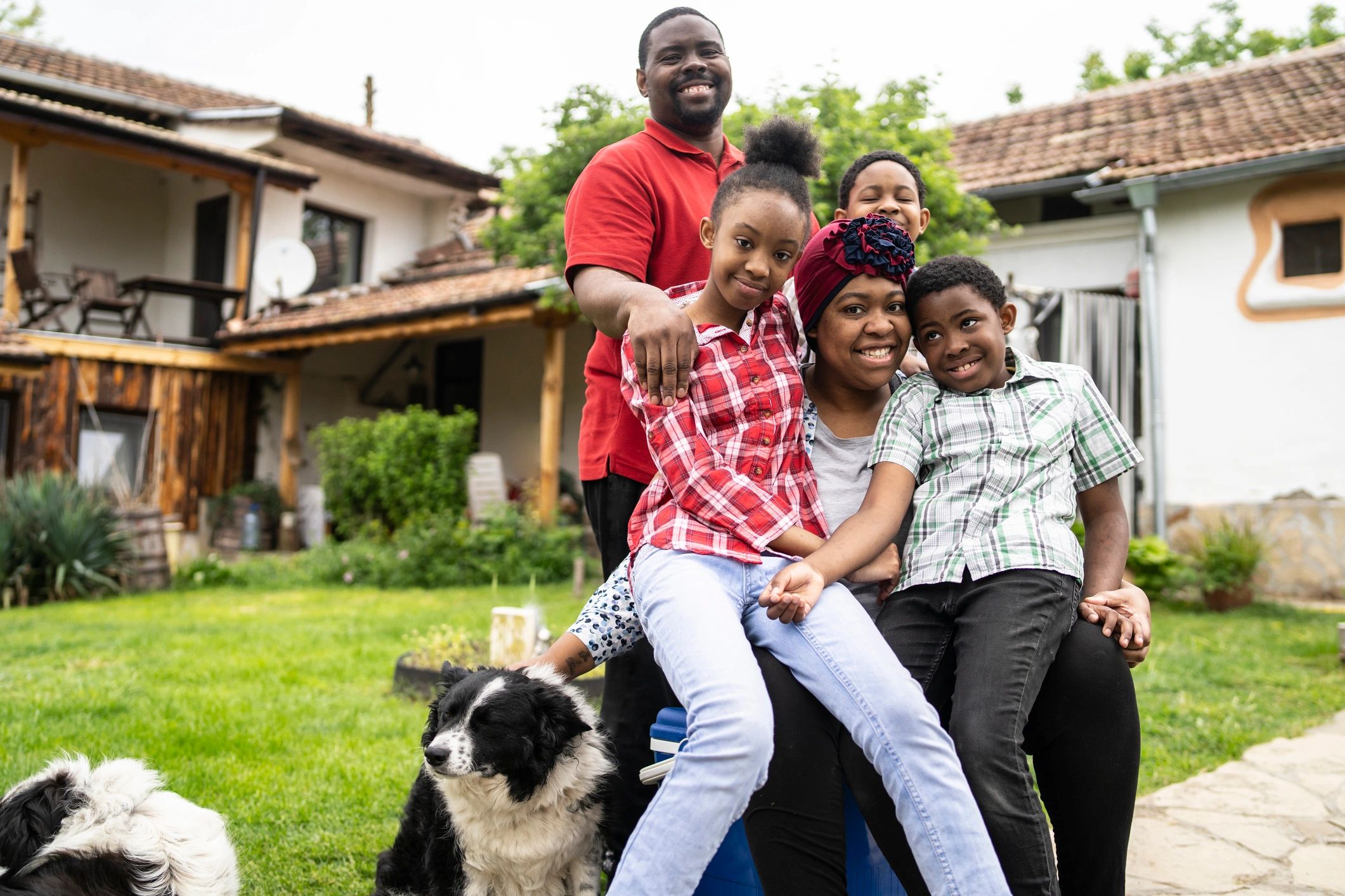 Happy family posing with their dog in the garden on a sunny day.