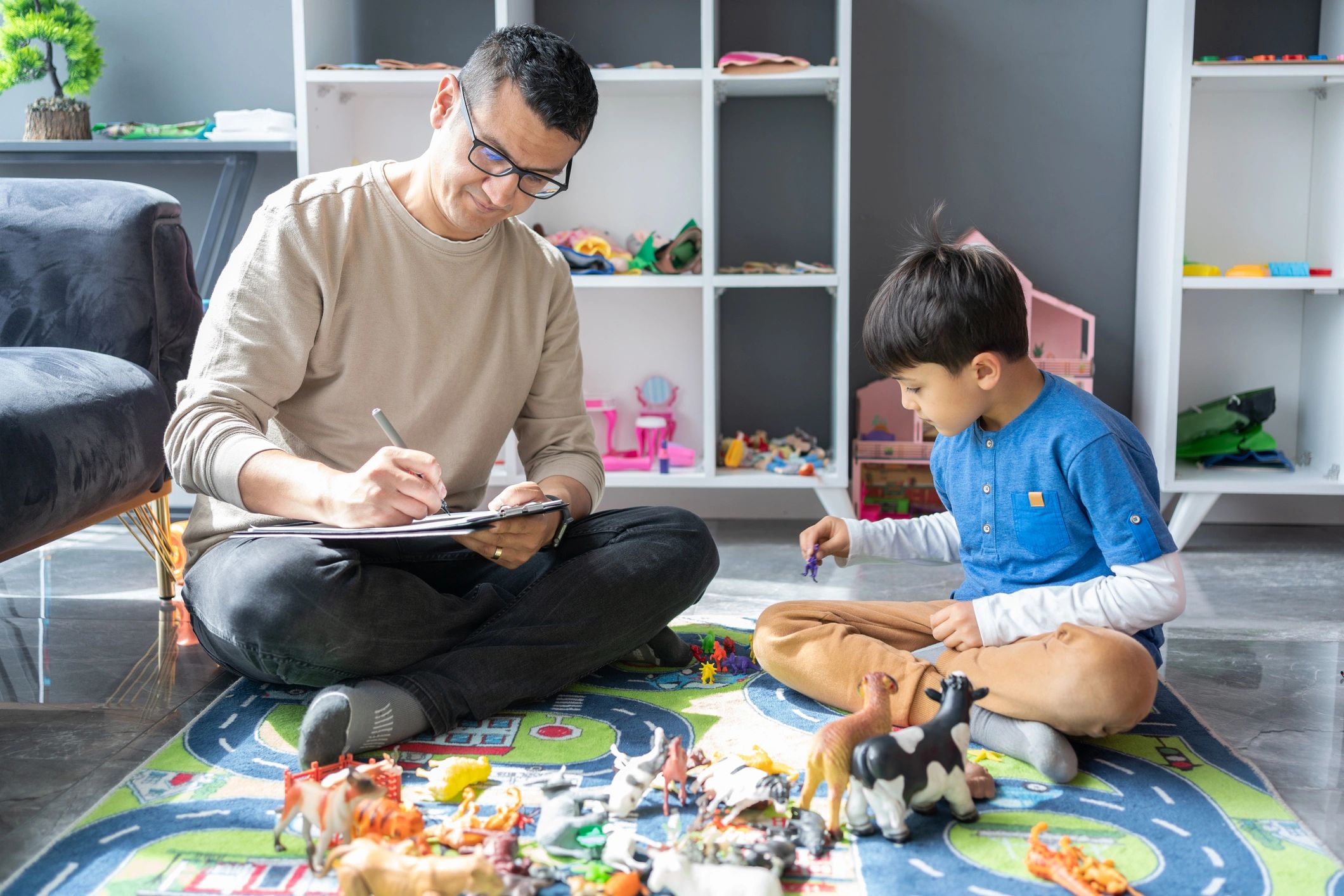 Father and son playing with toy animals.