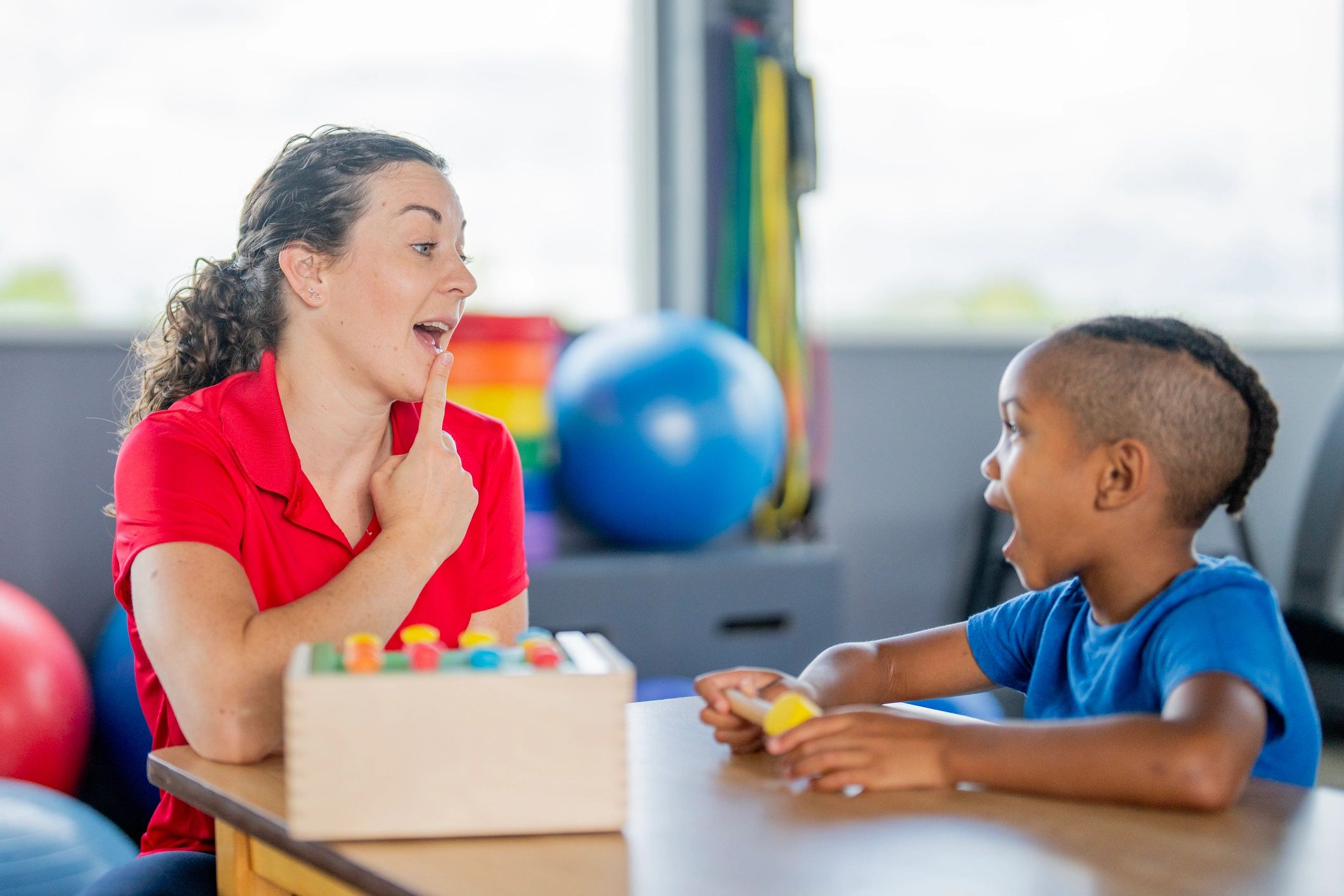 Therapist engaging with a child using toys in a playful session.