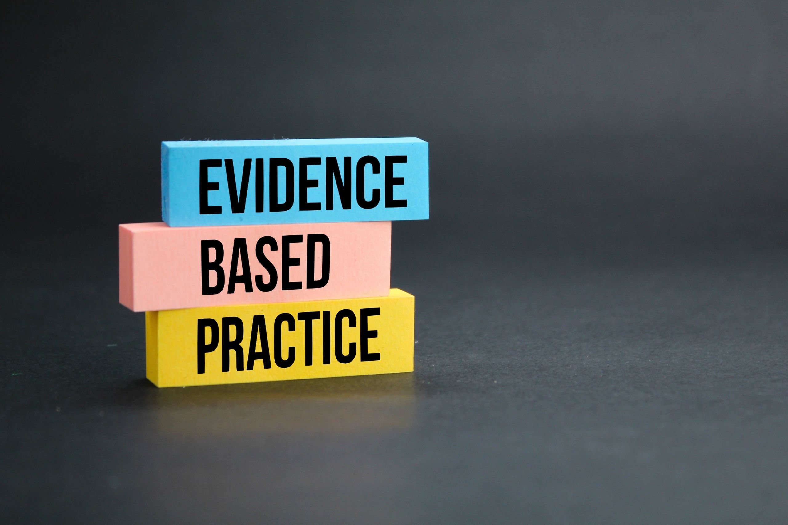 Colorful blocks spelling 'Evidence Based Practice' against a dark background.
