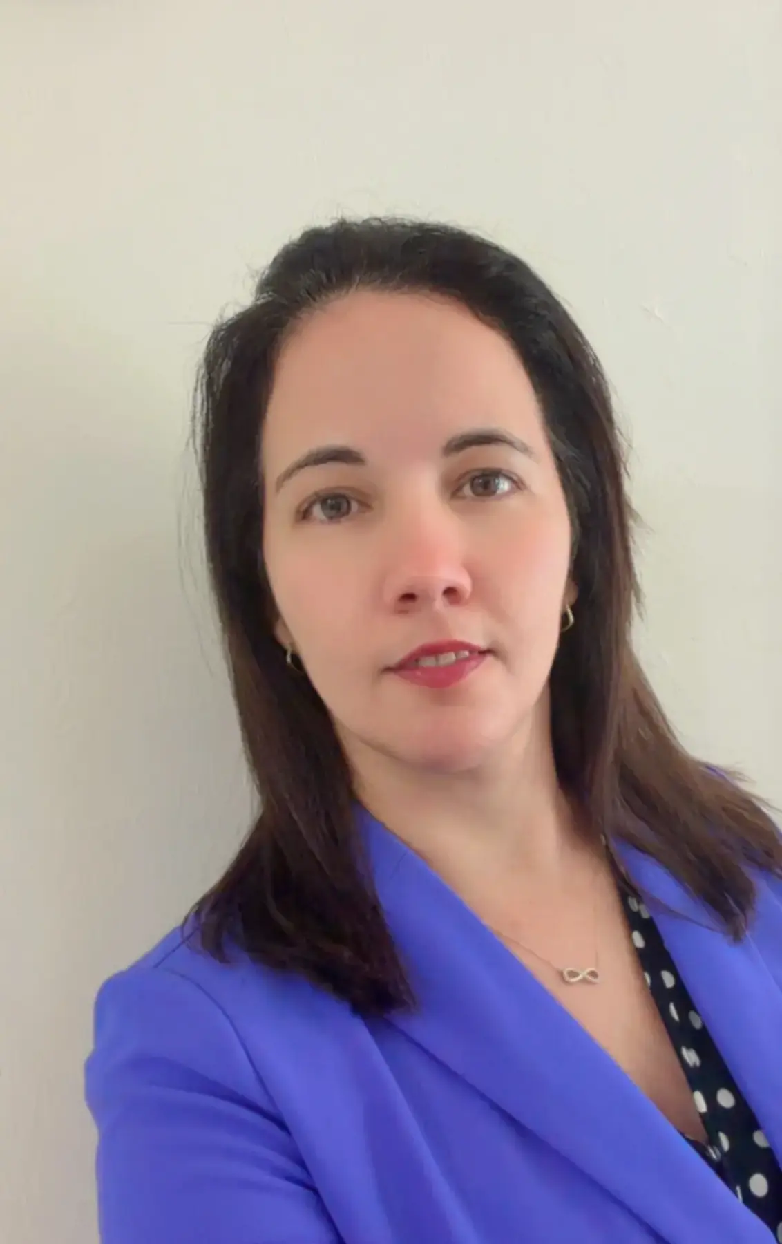 Portrait of a woman with long dark hair wearing a blue top.